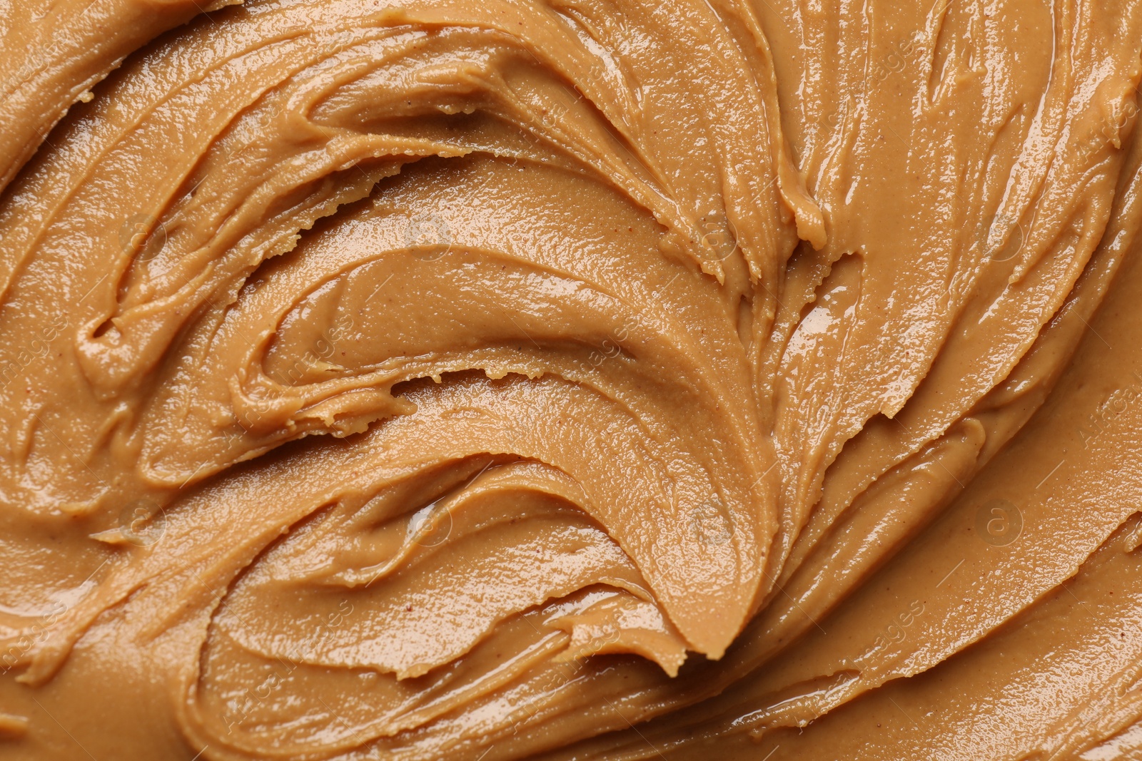 Photo of Tasty peanut butter as background, top view