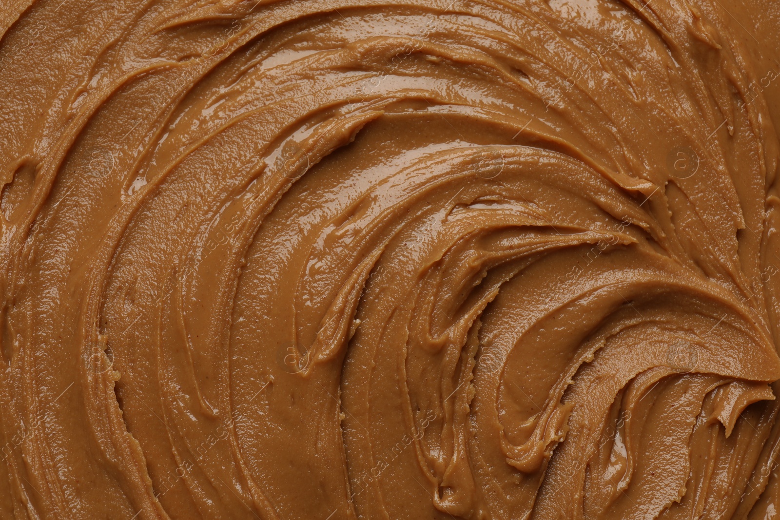 Photo of Tasty peanut butter as background, top view