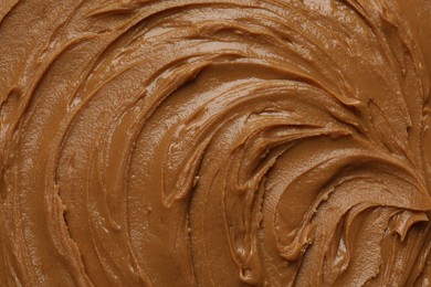 Photo of Tasty peanut butter as background, top view