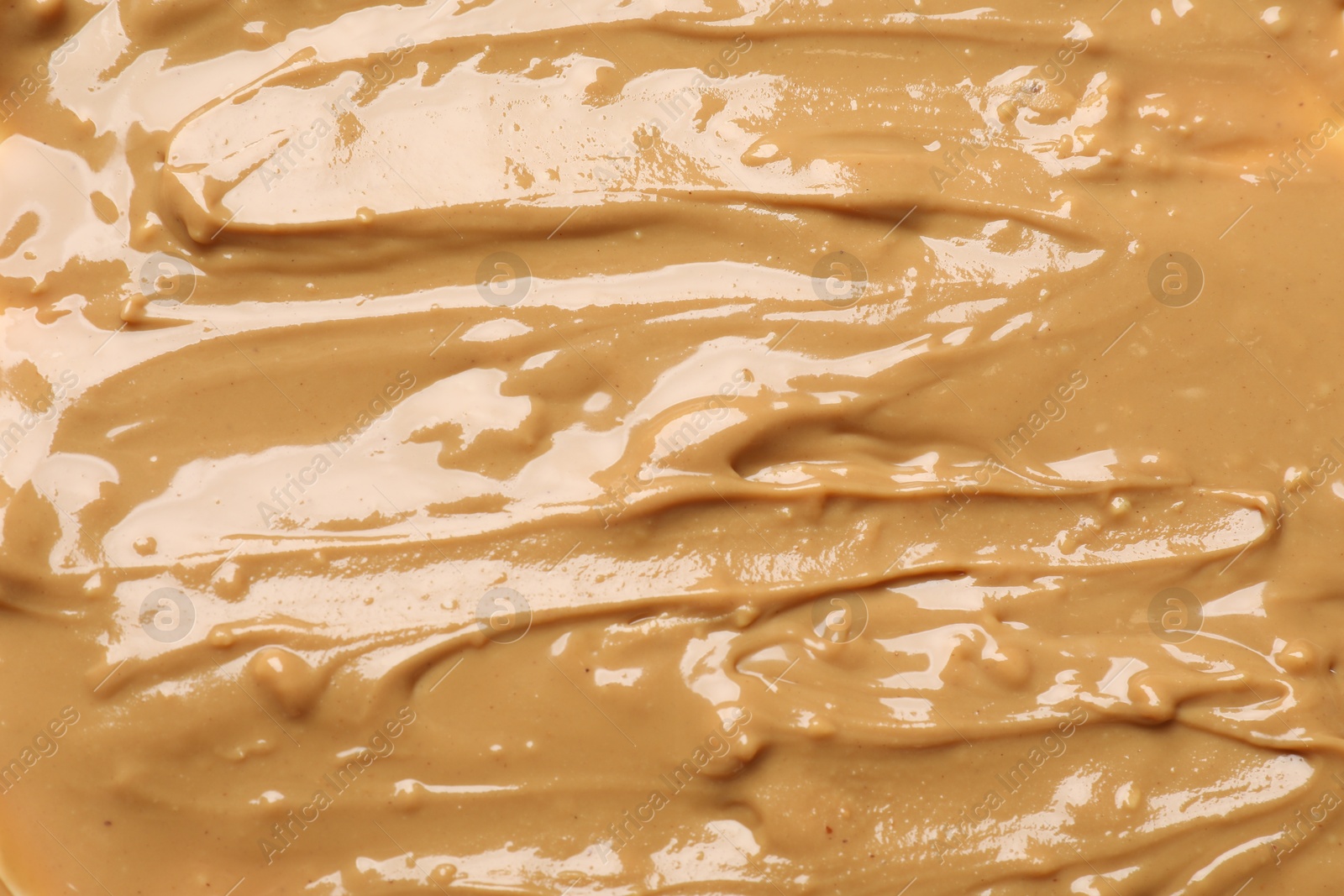 Photo of Tasty peanut butter as background, top view