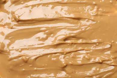 Photo of Tasty peanut butter as background, top view