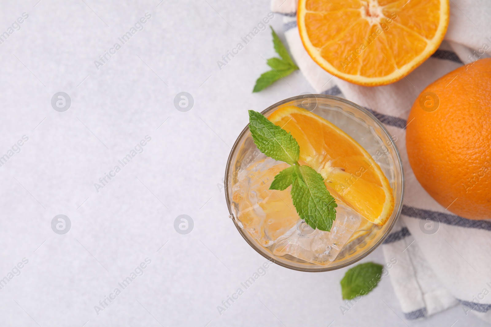 Photo of Refreshing water with orange and mint in glass on light table, flat lay. Space for text