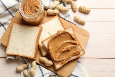 Delicious sandwich with peanut butter and nuts on white wooden table, flat lay