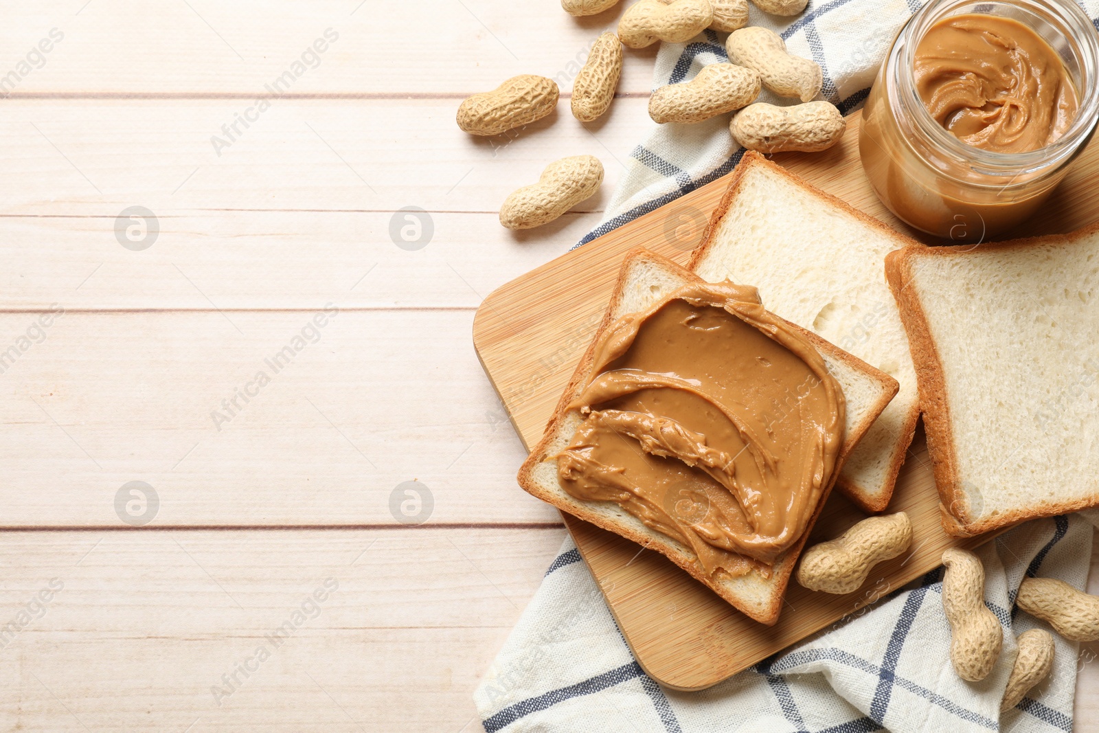 Photo of Delicious sandwich with peanut butter and nuts on white wooden table, flat lay