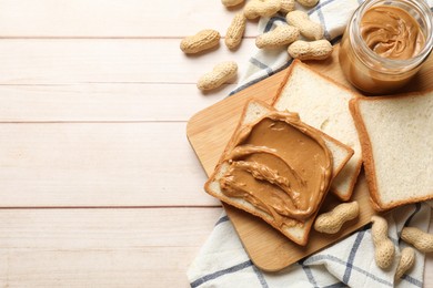 Photo of Delicious sandwich with peanut butter and nuts on white wooden table, flat lay