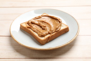 Photo of Delicious sandwich with peanut butter on white wooden table