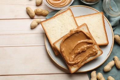 Delicious sandwich with peanut butter and nuts on white wooden table, flat lay