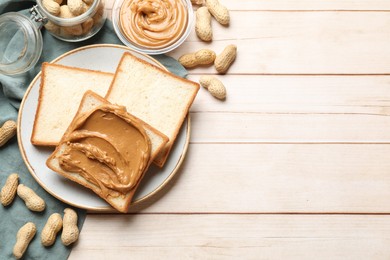 Delicious sandwich with peanut butter and nuts on white wooden table, flat lay