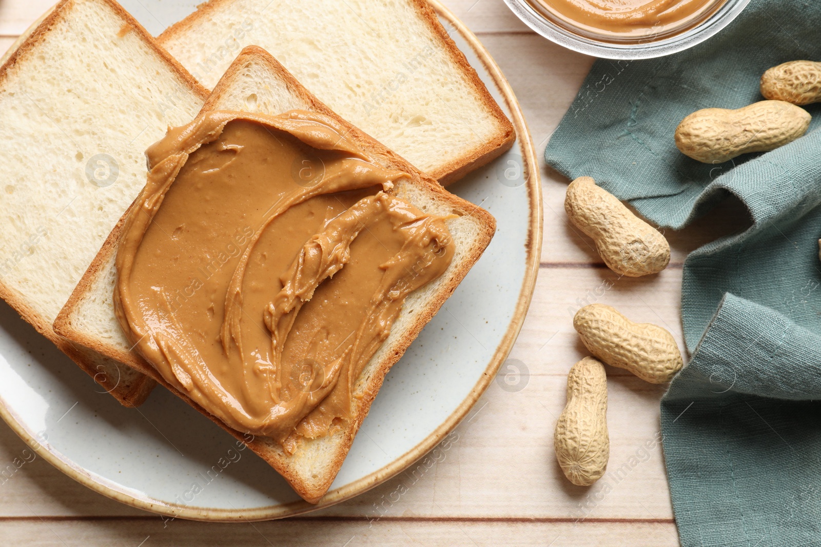 Photo of Delicious sandwich with peanut butter and nuts on white wooden table, flat lay