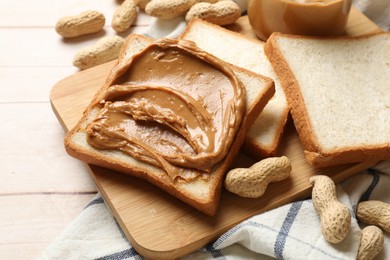 Delicious sandwich with peanut butter and nuts on white wooden table, closeup