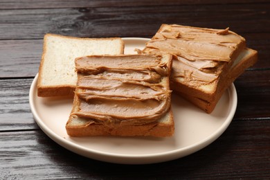 Delicious sandwiches with peanut butter on wooden table