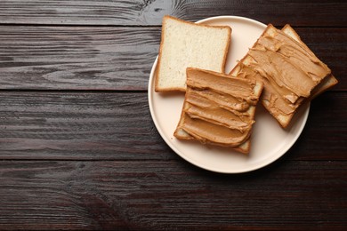 Delicious sandwiches with peanut butter on wooden table, top view