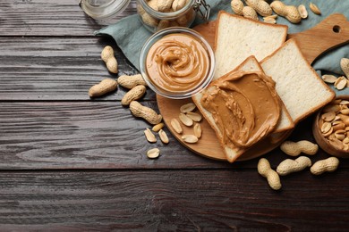 Photo of Delicious sandwich with peanut butter and nuts on wooden table