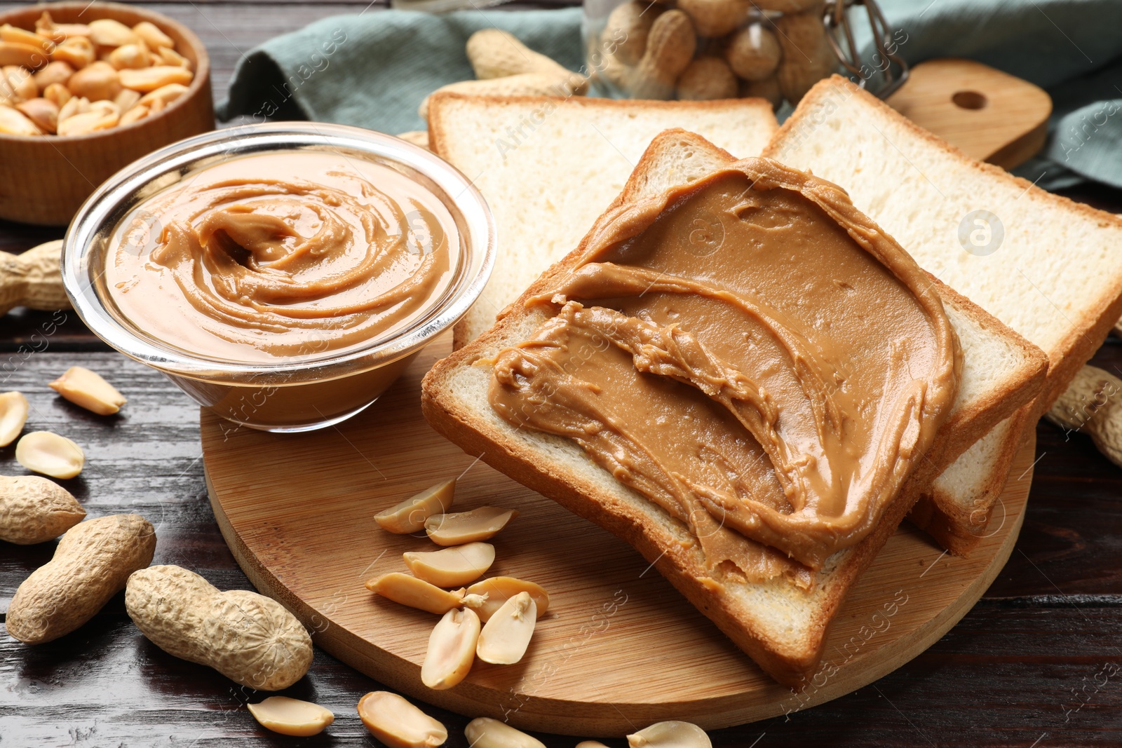 Photo of Delicious sandwich with peanut butter and nuts on wooden table, closeup