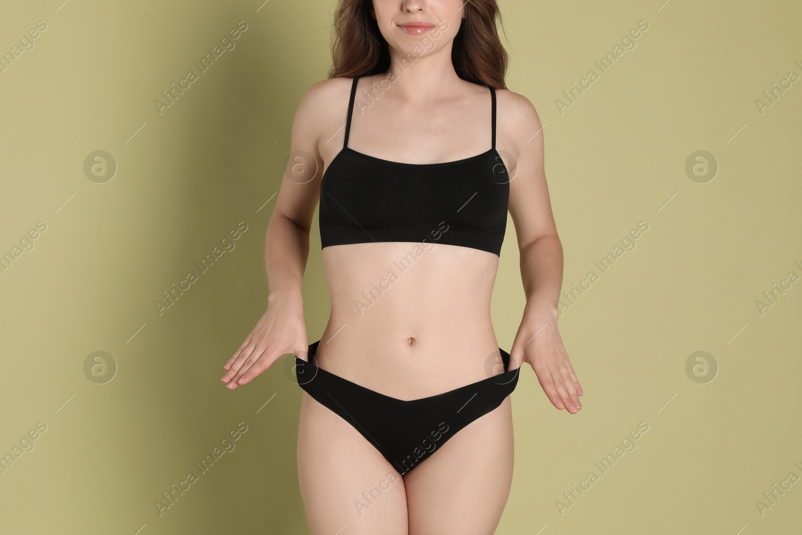 Photo of Woman with slim body posing on olive background, closeup