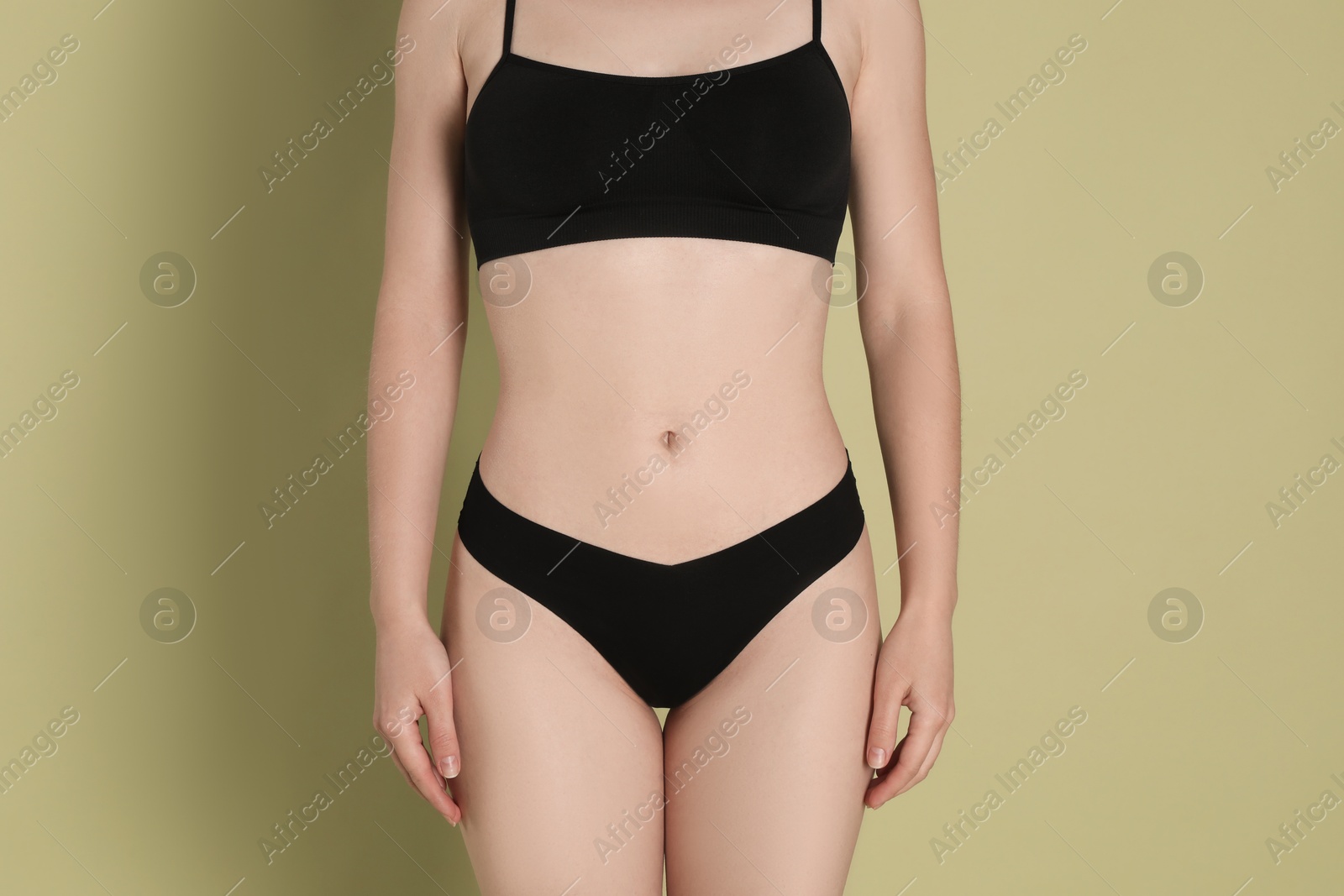 Photo of Woman with slim body posing on olive background, closeup