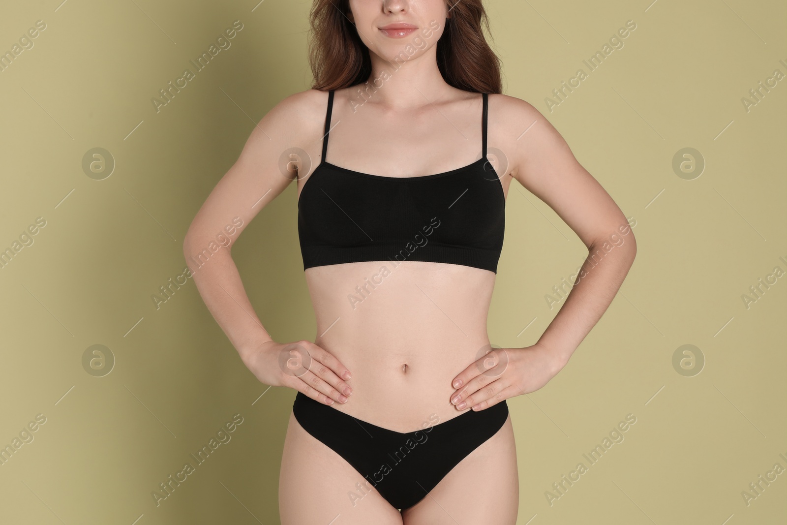 Photo of Woman with slim body posing on olive background, closeup