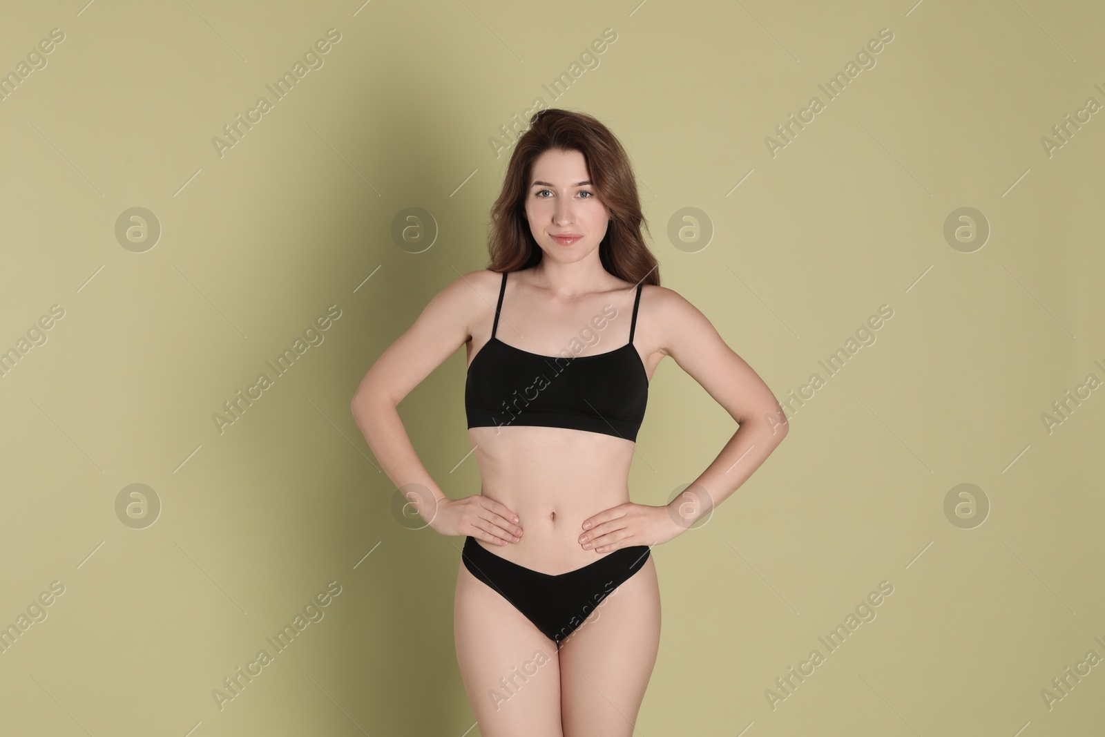 Photo of Woman with slim body posing on olive background