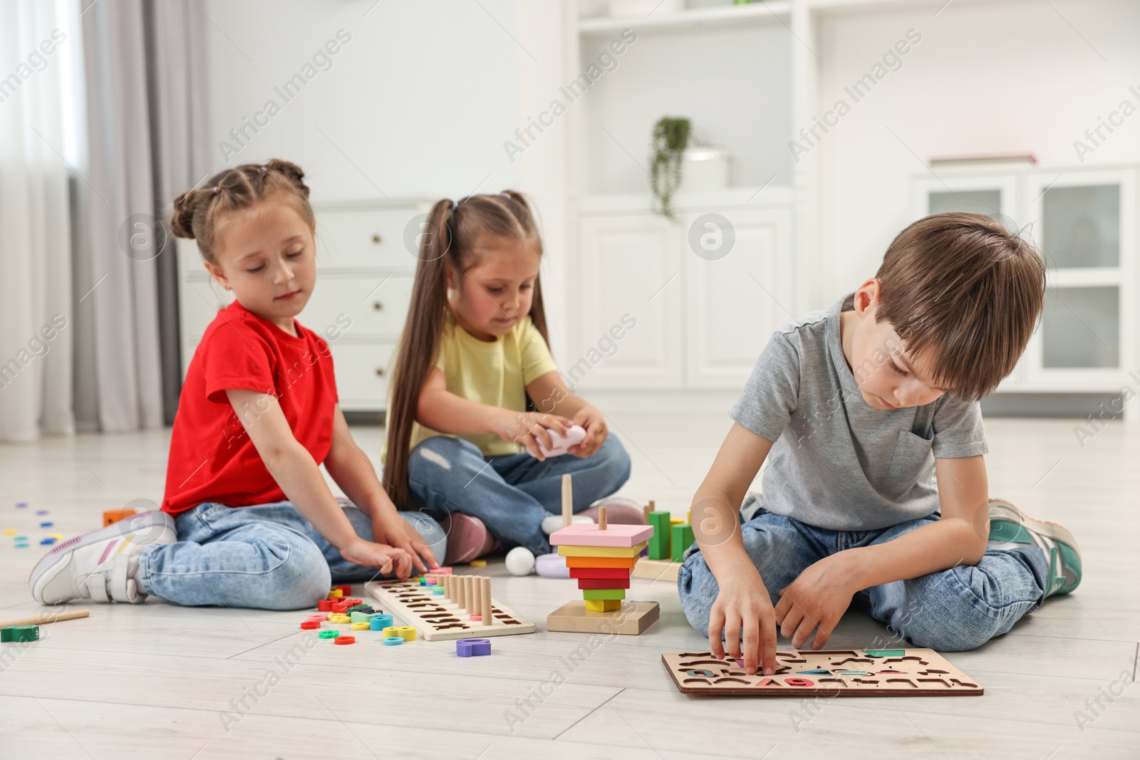 Photo of Cute little children playing together on floor indoors