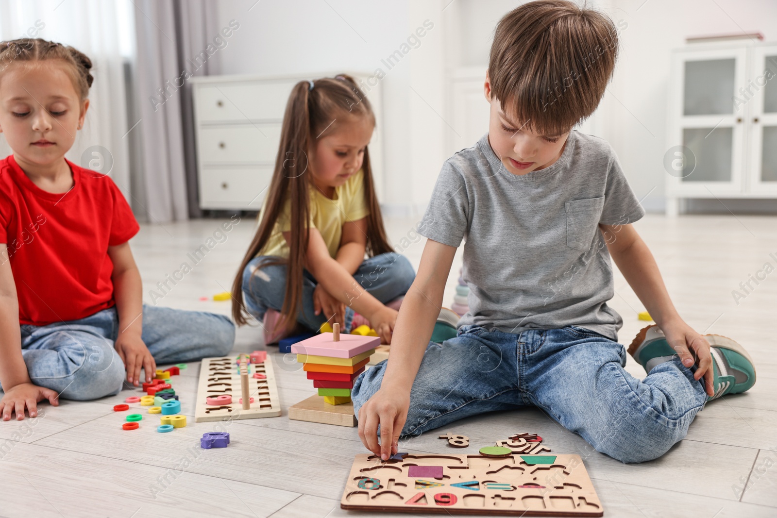 Photo of Cute little children playing together on floor indoors