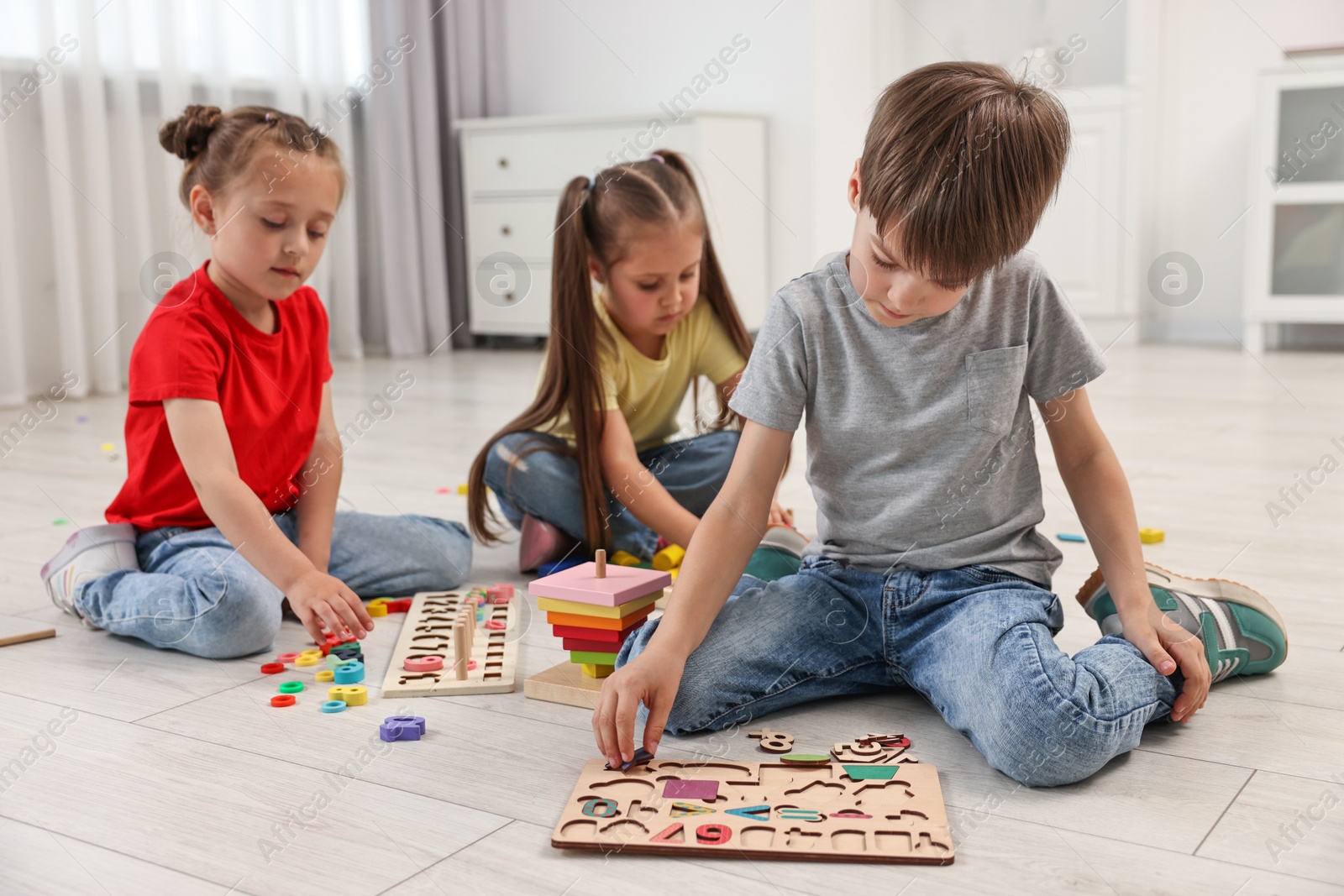 Photo of Cute little children playing together on floor indoors