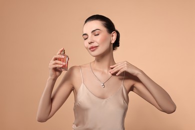 Photo of Beautiful woman with bottle of perfume on beige background