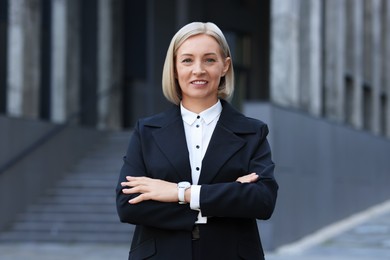 International relations. Diplomat with crossed arms in suit outdoors