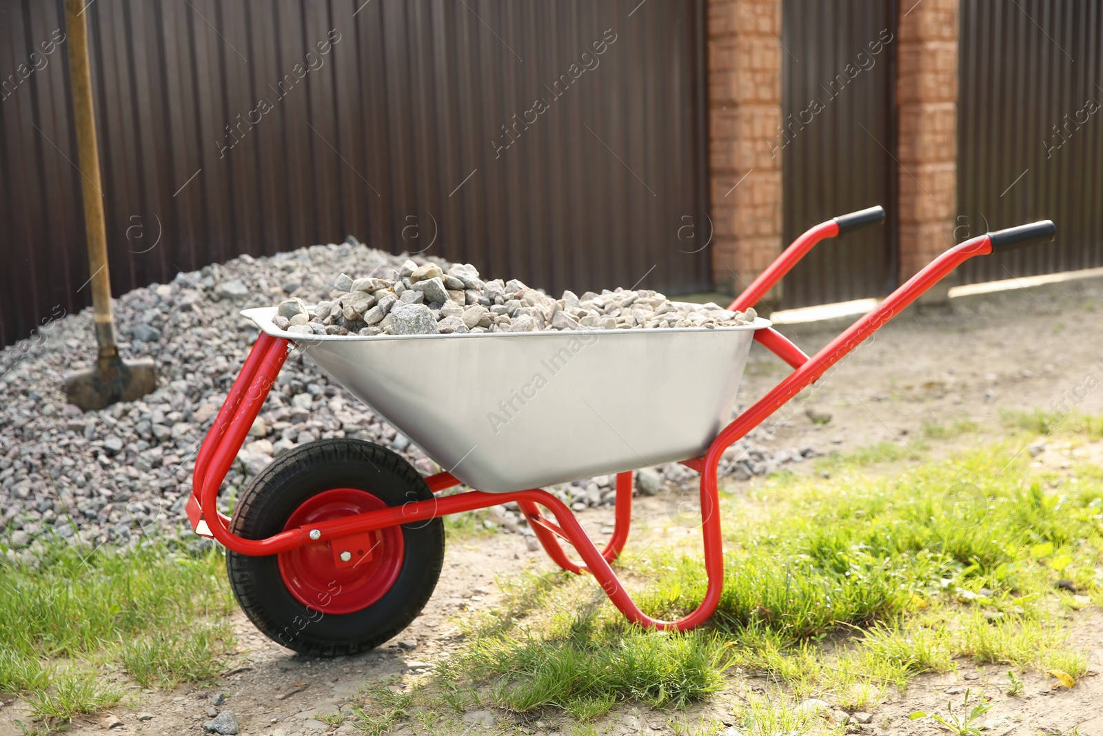 Photo of Wheelbarrow full of stones outdoors on sunny day