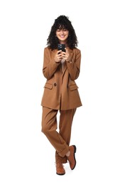 Beautiful young woman in stylish suit using smartphone on white background