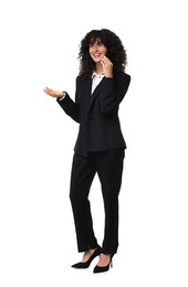 Beautiful young woman in black suit talking on smartphone against white background