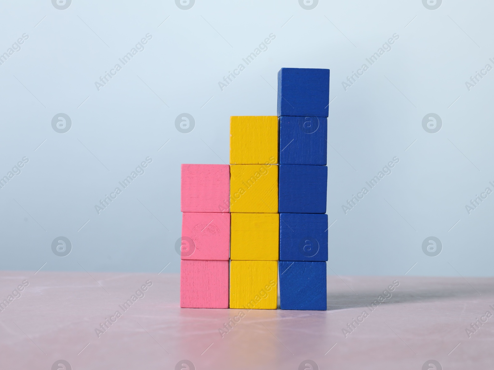 Photo of Blank colorful cubes on light grey marble table