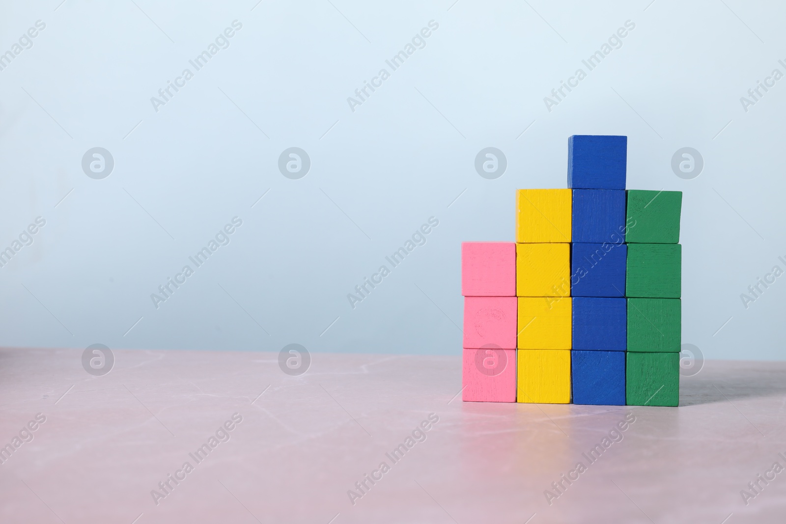 Photo of Blank colorful cubes on light grey marble table, space for text