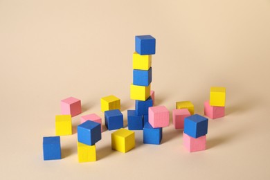 Photo of Many blank colorful cubes on beige background