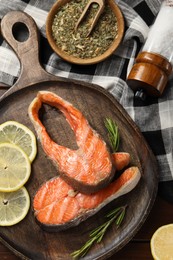 Photo of Tasty grilled salmon steaks, lemon and spices on table, flat lay