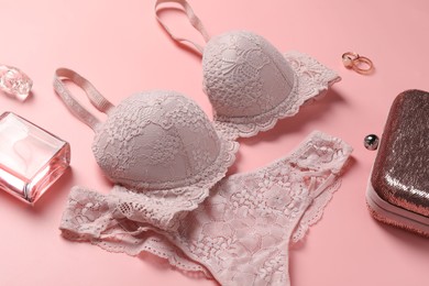 Photo of Elegant lace women's underwear, jewellery, bag and perfume on pink background