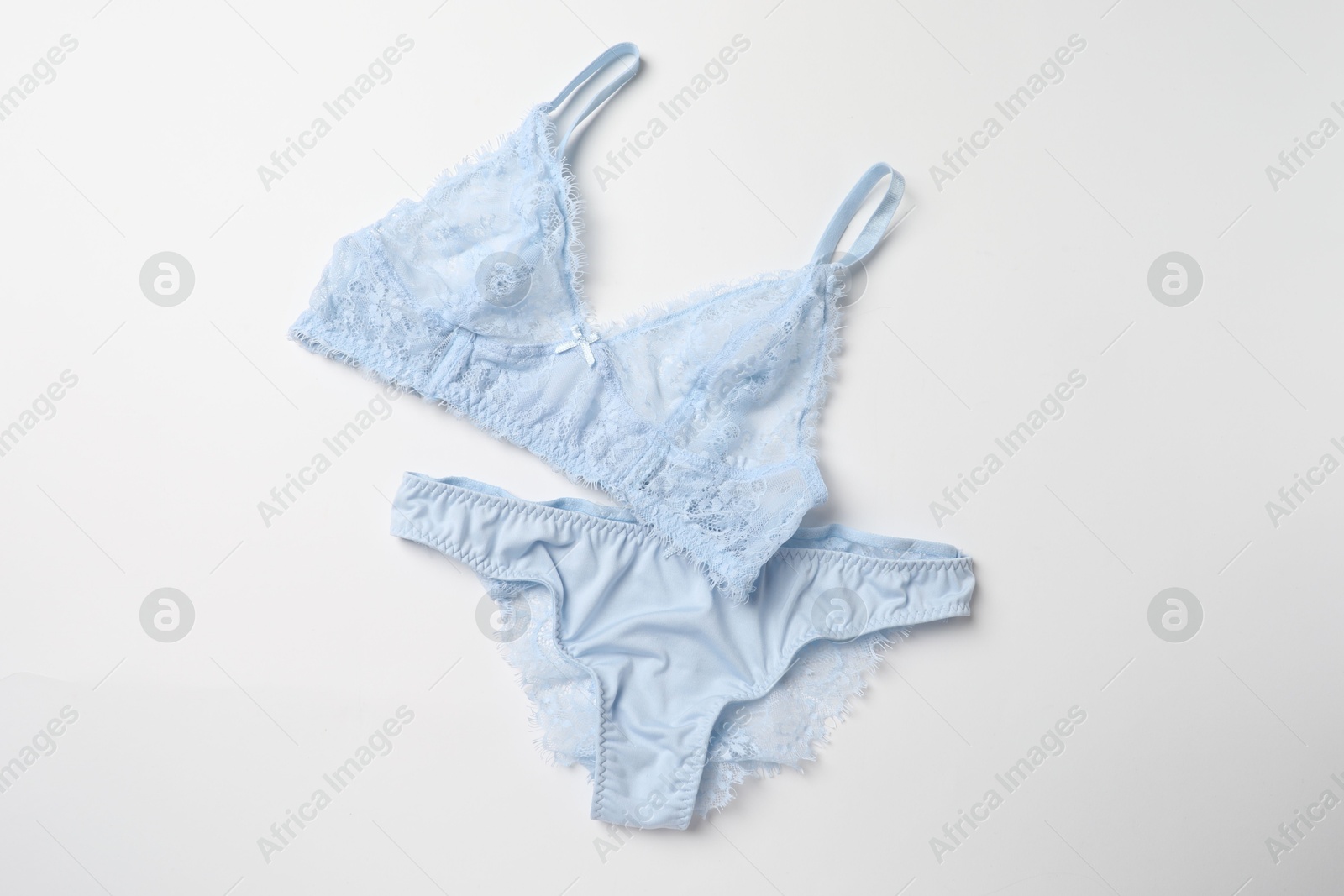 Photo of Elegant light blue lace women's underwear isolated on white, top view