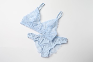 Photo of Elegant light blue lace women's underwear isolated on white, top view