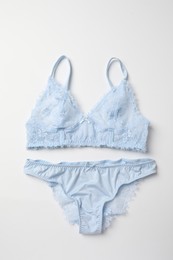 Elegant light blue lace women's underwear isolated on white, top view