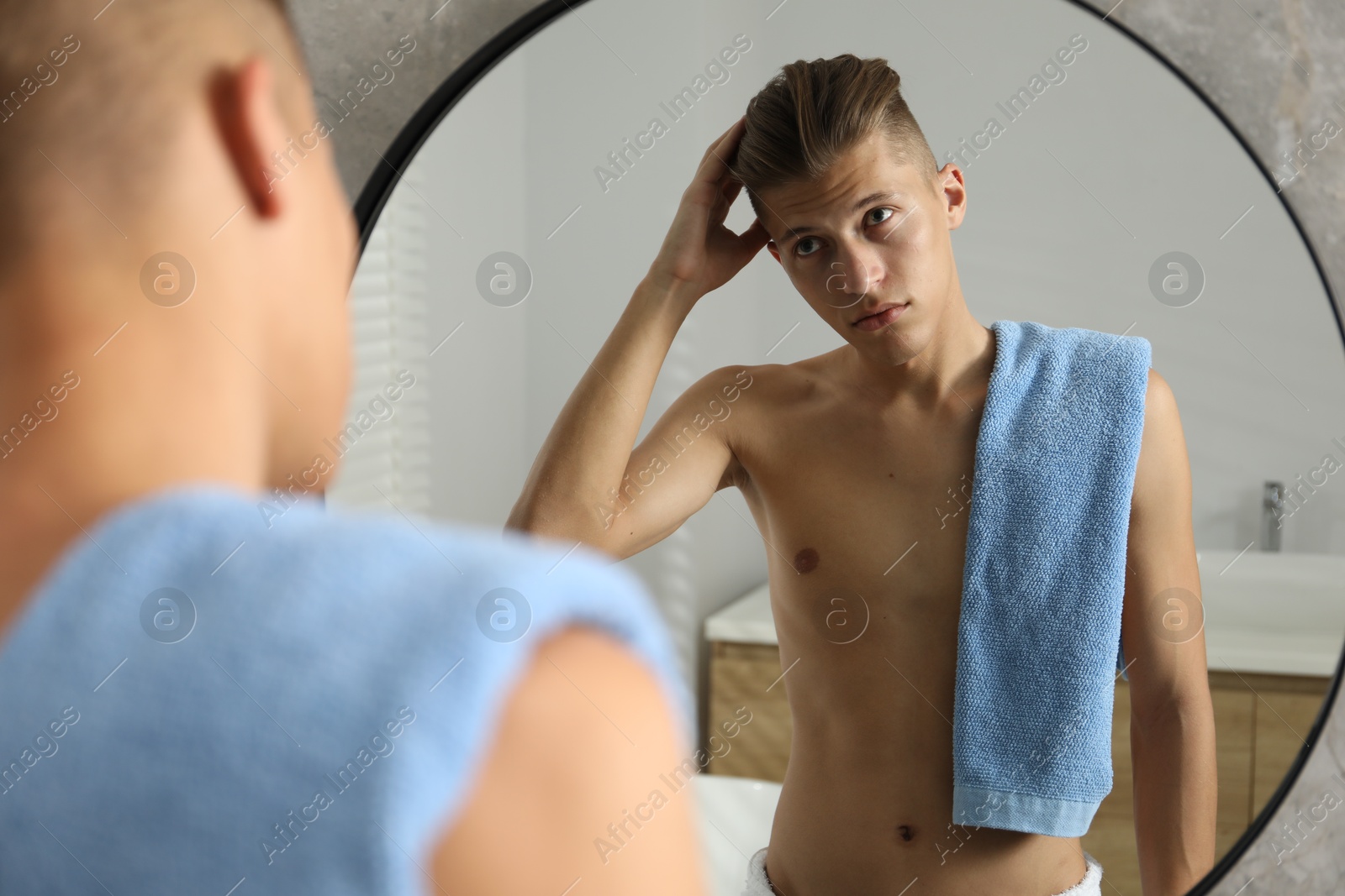 Photo of Handsome man looking at mirror in bathroom