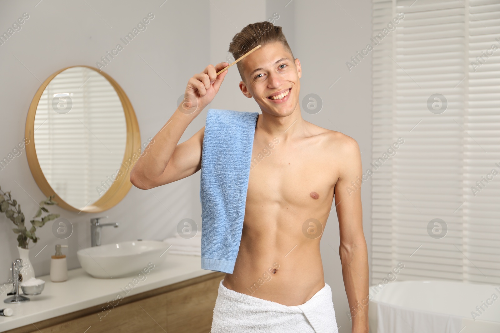 Photo of Handsome man with comb and towel in bathroom