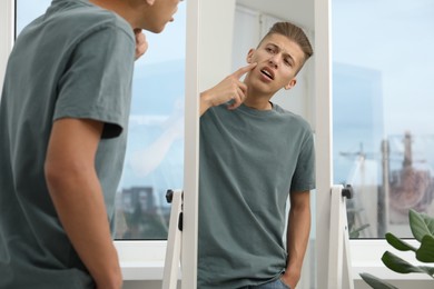 Photo of Man touching his face near mirror indoors