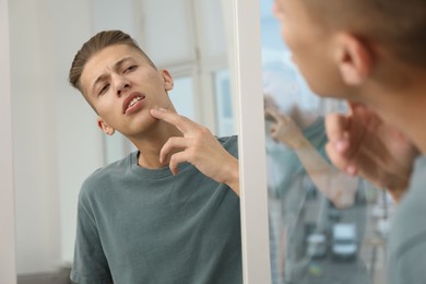 Photo of Man touching his face near mirror indoors