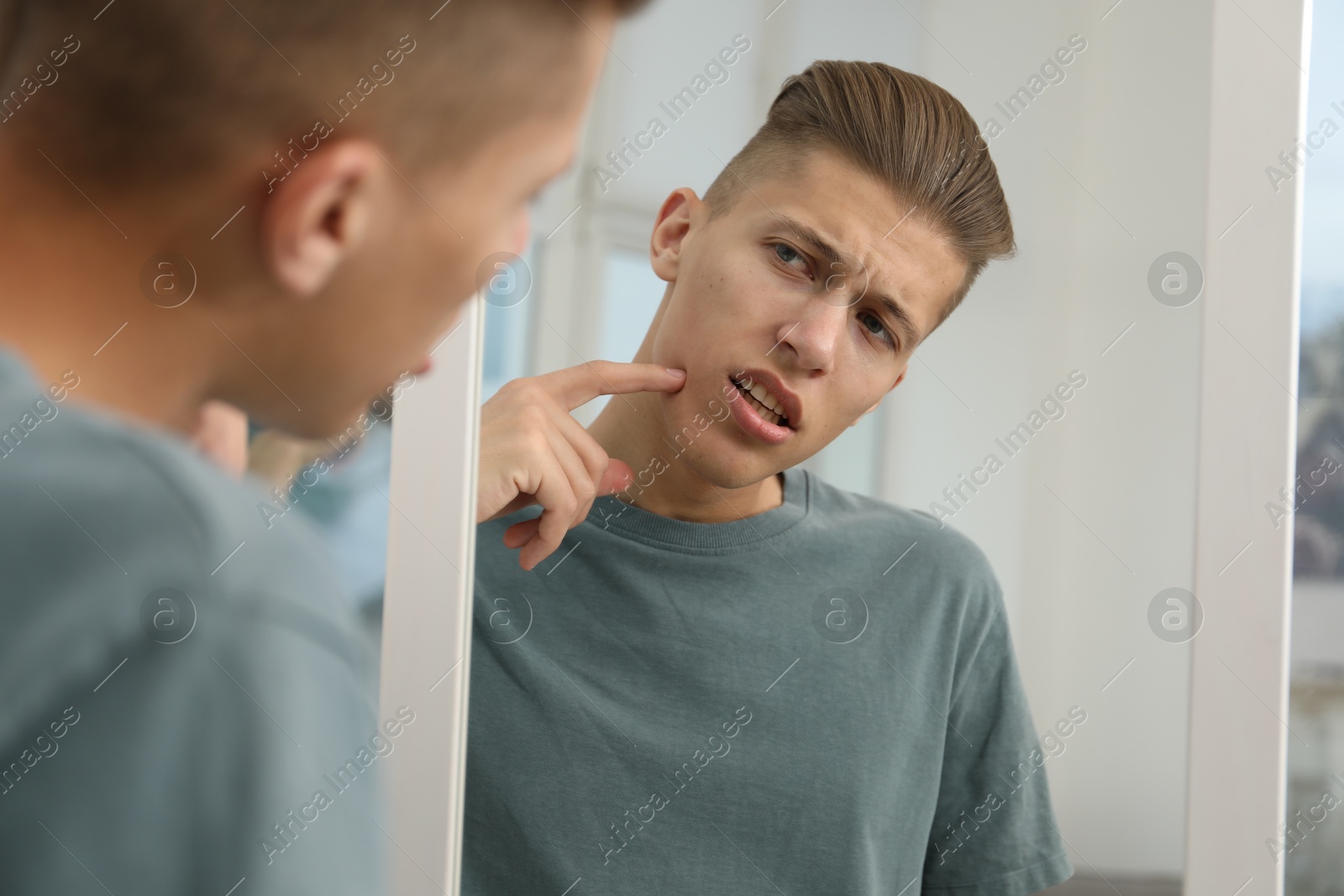 Photo of Man touching his face near mirror indoors