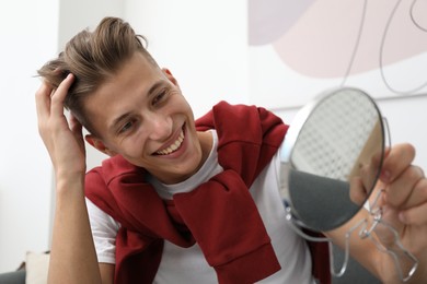 Photo of Handsome man looking at mirror at home