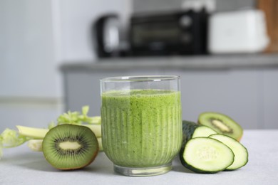 Photo of Delicious green smoothie and ingredients on light table