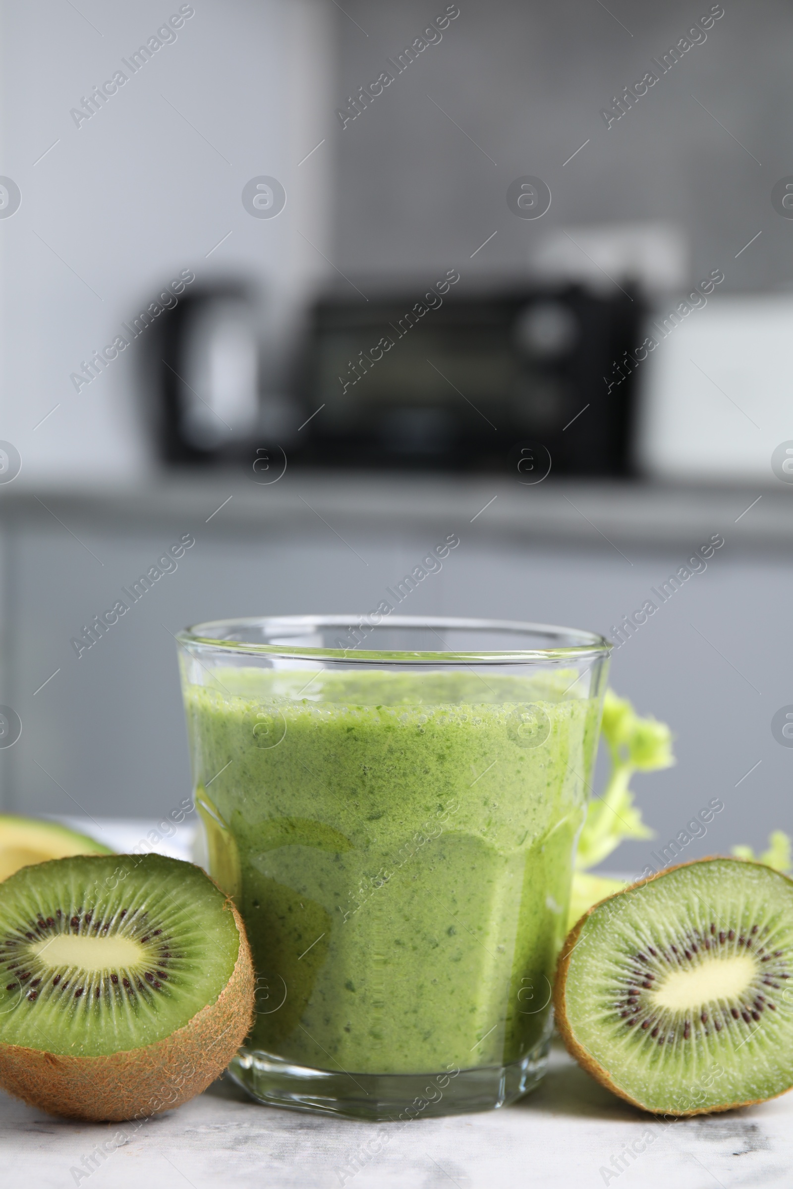 Photo of Delicious green smoothie and ingredients on white table