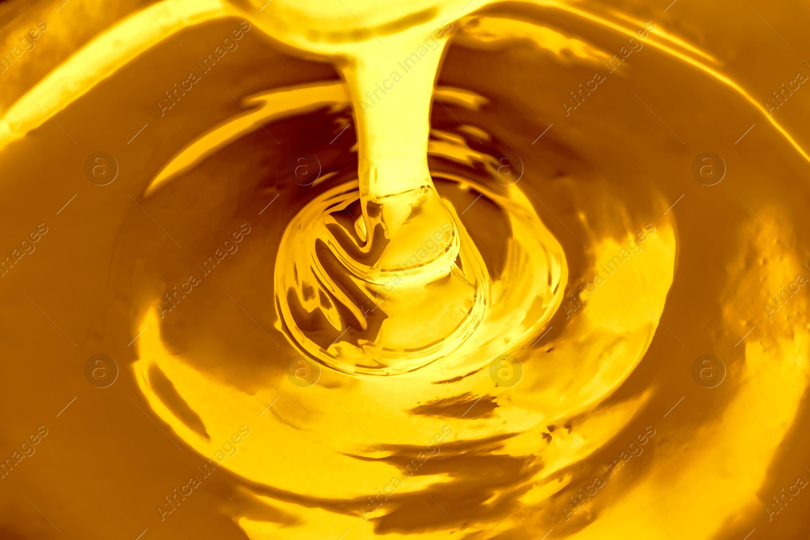 Image of Pouring gold fluid as background, closeup view