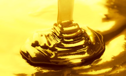 Image of Pouring gold fluid as background, closeup view