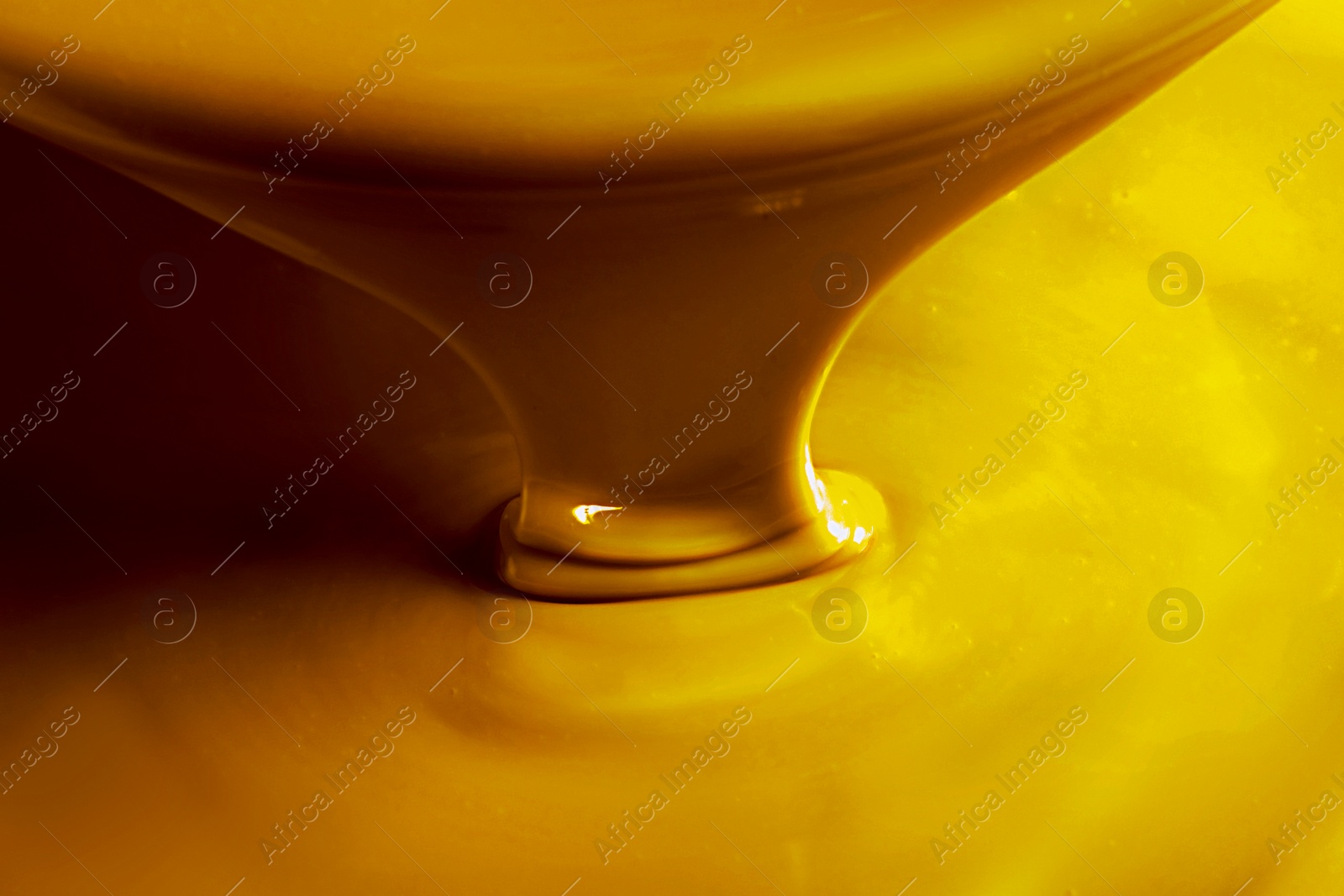 Image of Pouring gold fluid as background, closeup view