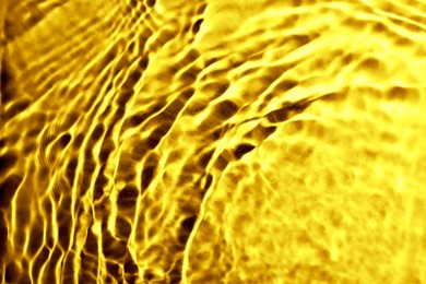 Image of Gold fluid with ripples as background, closeup